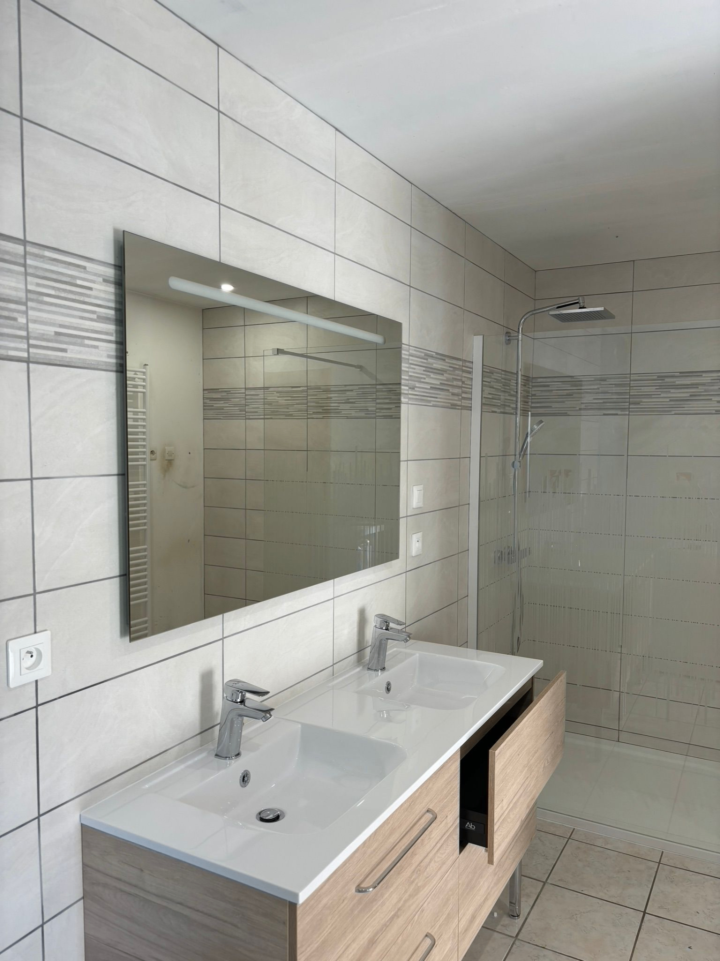 Salle de bains lumineuse double vasque et douche à l'italienne — réalisation DLR Chauffage